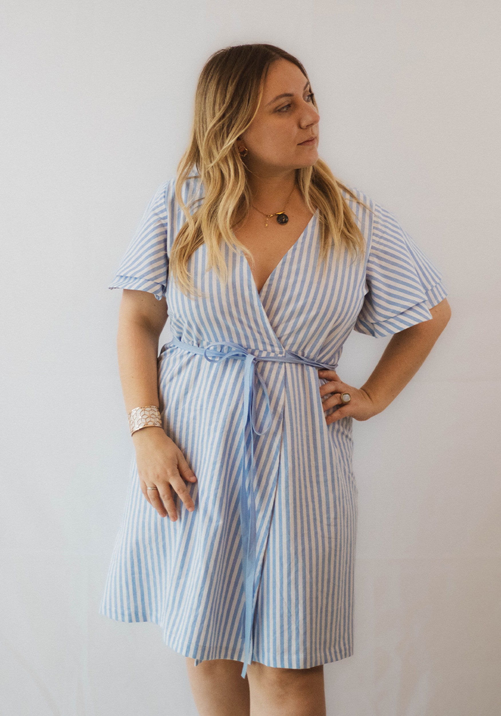 La robe ' Alice ', coupe portefeuille, longueur genoux et doubles manches papillons.